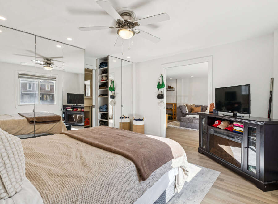 Step into this bright and airy bedroom, featuring a large mirrored closet and a cozy bed.