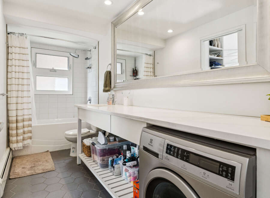 This modern bathroom features a sleek design with a built-in washing machine, maximizing space and convenience.