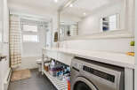 This modern bathroom features a sleek design with a built-in washing machine, maximizing space and convenience.