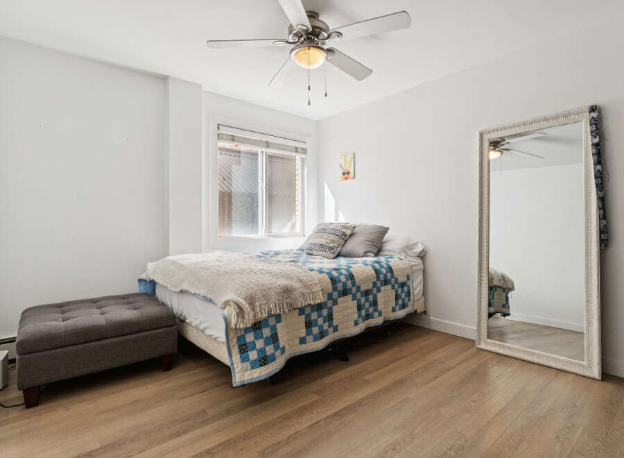 This cozy bedroom features a comfortable bed with a stylish quilt and a decorative throw, perfect for a relaxing retreat.