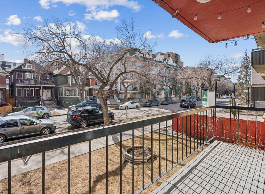 Enjoy stunning views from this charming property, featuring a private balcony overlooking a tree-lined street.