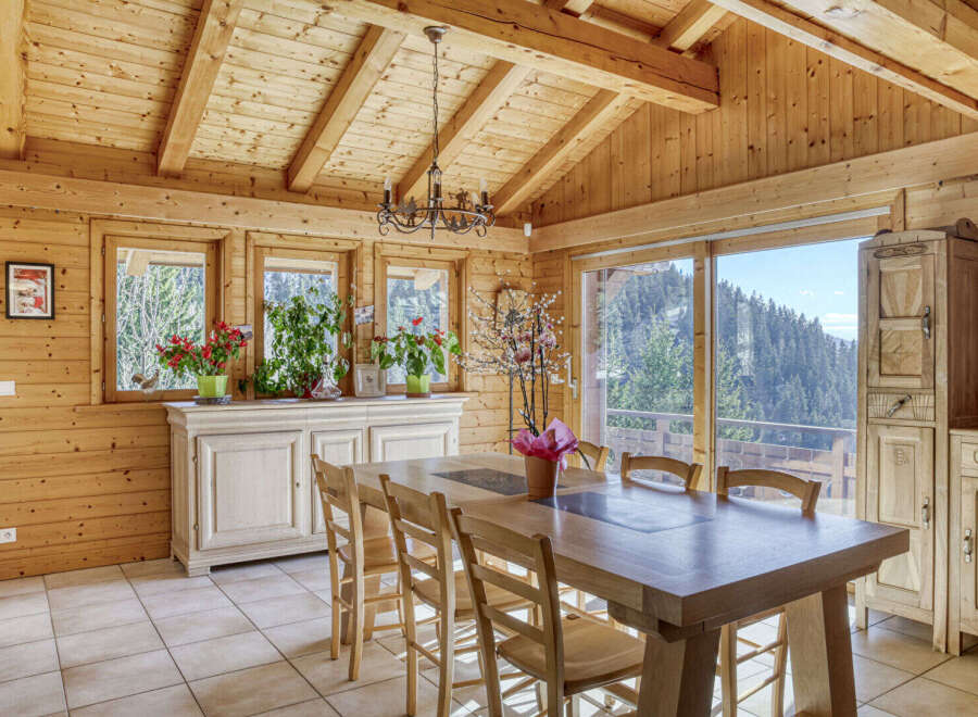 Step into this stunning chalet-style dining room, boasting a warm and inviting ambiance with its wooden walls and ceiling.