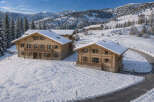 Experience luxurious mountain living in this stunning chalet nestled in a snowy alpine landscape.