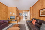 Discover the charm of this cozy living space, featuring warm wooden paneling and a comfortable leather sofa.
