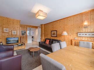 This charming living space features warm wood paneling, creating a cozy and inviting atmosphere.
