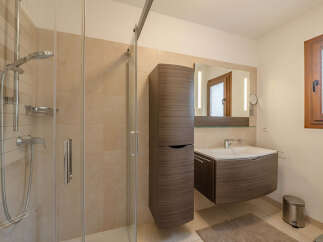 Step into a modern bathroom oasis! This beautifully designed space features a sleek shower enclosure, a stylish vanity with ample storage, and a large mirror.