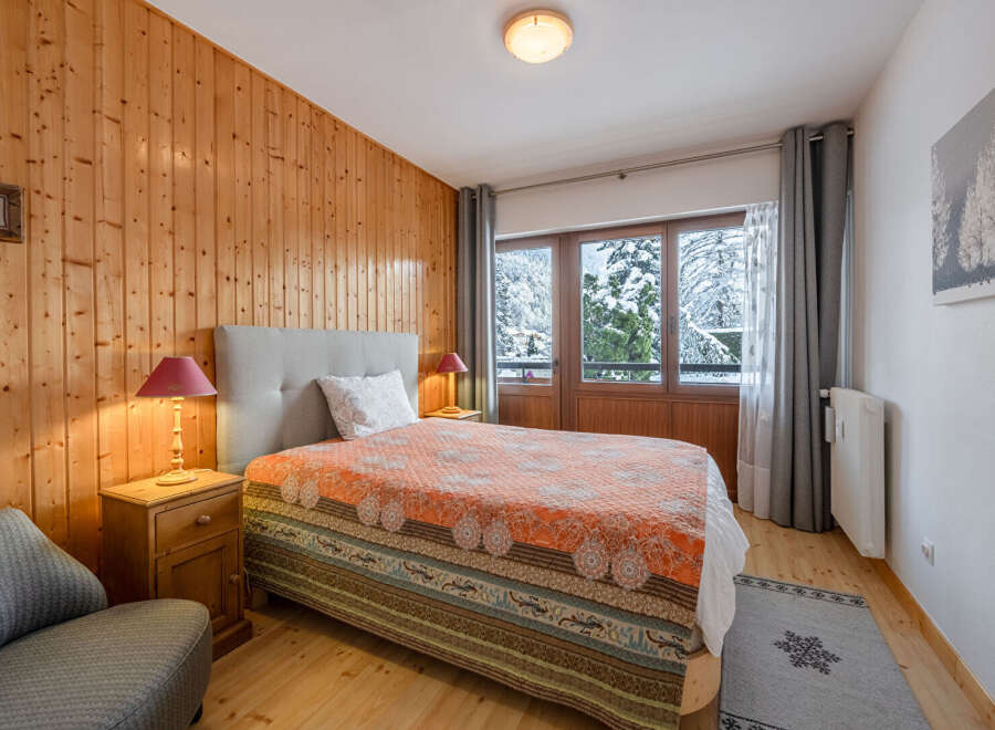 This cozy bedroom features a warm wooden paneling, creating a rustic and inviting atmosphere.