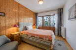 This cozy bedroom features a warm wooden paneling, creating a rustic and inviting atmosphere.