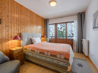 This cozy bedroom features a warm wooden paneling, creating a rustic and inviting atmosphere.