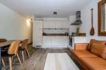Discover this stylish apartment featuring a modern kitchen with sleek white cabinetry and stainless steel appliances.