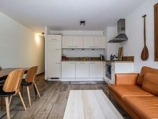 Discover this stylish apartment featuring a modern kitchen with sleek white cabinetry and stainless steel appliances.