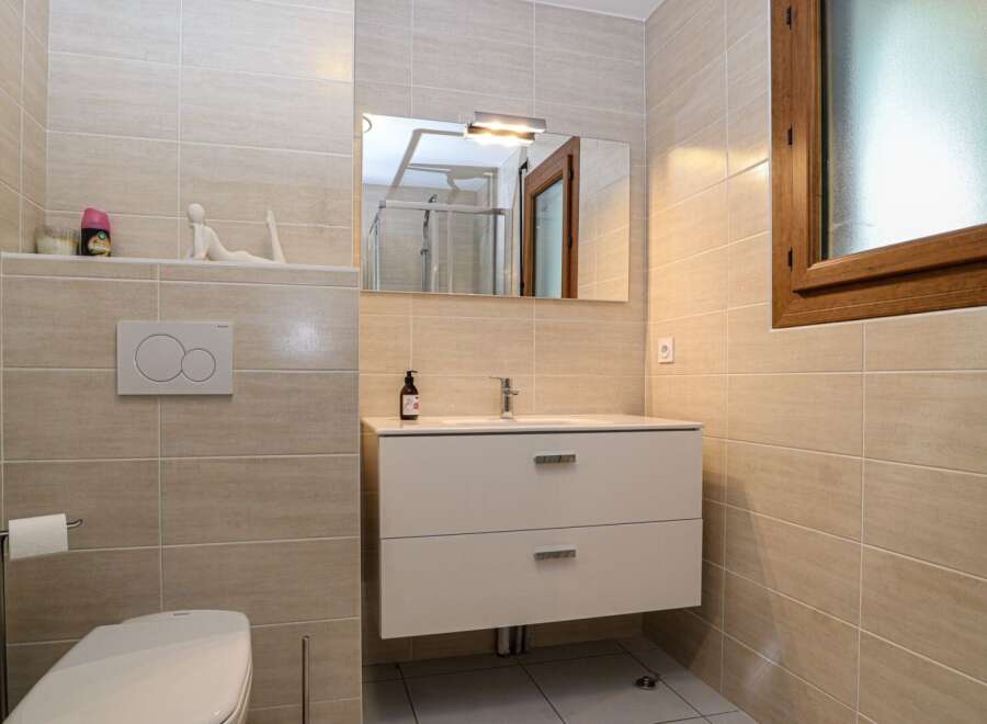This modern bathroom features a sleek design with neutral-toned tiles and a minimalist aesthetic.