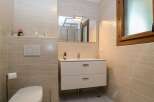 This modern bathroom features a sleek design with neutral-toned tiles and a minimalist aesthetic.