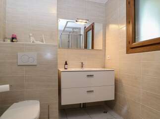 This modern bathroom features a sleek design with neutral-toned tiles and a minimalist aesthetic.