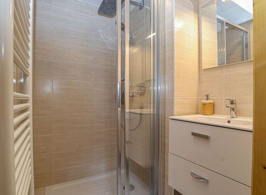 Step into a modern bathroom featuring a sleek shower enclosure and stylish vanity.