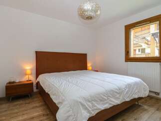 This cozy bedroom features a comfortable bed with a stylish headboard, perfect for a relaxing retreat.