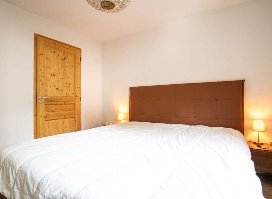This cozy bedroom features a comfortable bed with a stylish headboard, perfect for a relaxing retreat.
