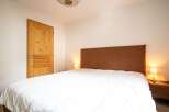 This cozy bedroom features a comfortable bed with a stylish headboard, perfect for a relaxing retreat.