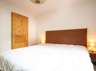This cozy bedroom features a comfortable bed with a stylish headboard, perfect for a relaxing retreat.