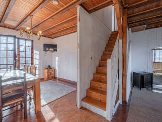 This charming property features a warm and inviting interior with exposed wooden beams and a cozy atmosphere.