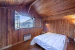 This charming bedroom boasts a cozy, wood-paneled interior, creating a warm and inviting atmosphere.