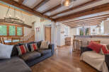 Step into this stunning property featuring a cozy living area with a comfortable sectional sofa and a beautiful chandelier.