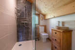 This charming bathroom features a rustic wooden vanity with a stone sink, adding a touch of natural elegance.
