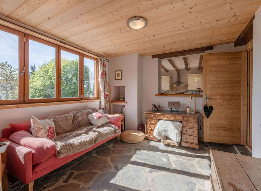 Discover the charm of this cozy living space, featuring a warm wooden ceiling and inviting natural light.
