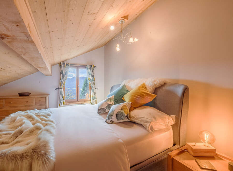 This cozy bedroom features a charming wooden ceiling and a comfortable bed, perfect for a relaxing retreat.