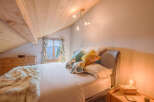 This cozy bedroom features a charming wooden ceiling and a comfortable bed, perfect for a relaxing retreat.