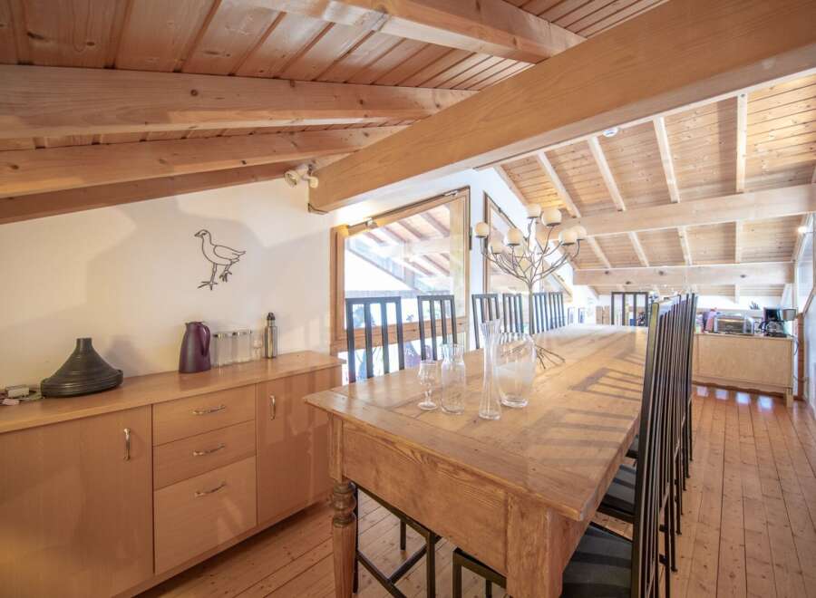 This stunning dining area boasts a rustic charm with its wooden table and chairs, perfect for hosting gatherings.