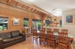 Step into this charming cabin-style home, featuring a warm and inviting interior with exposed wooden beams and paneling.