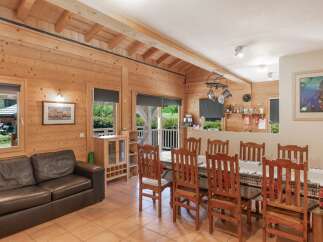 Step into this charming cabin-style home, featuring a warm and inviting interior with exposed wooden beams and paneling.