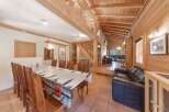 Step into this charming chalet-style home, boasting a warm and inviting interior with exposed wooden beams and paneling.