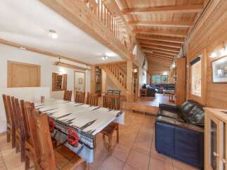 Step into this charming chalet-style home, boasting a warm and inviting interior with exposed wooden beams and paneling.