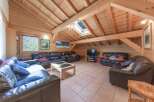 Discover the charm of this stunning living room, featuring a unique wooden ceiling and walls that create a warm and inviting atmosphere.