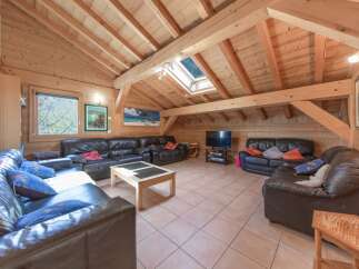 Discover the charm of this stunning living room, featuring a unique wooden ceiling and walls that create a warm and inviting atmosphere.