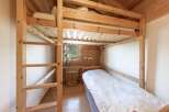 Discover the charm of this cozy bedroom featuring a unique wooden bunk bed, perfect for maximizing space.
