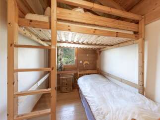 Discover the charm of this cozy bedroom featuring a unique wooden bunk bed, perfect for maximizing space.