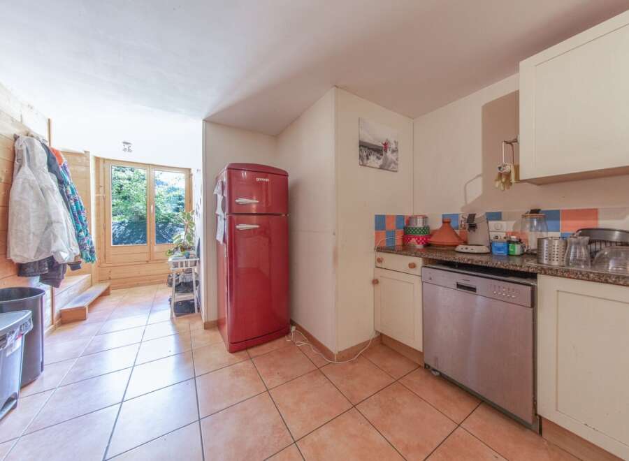 Discover this charming property featuring a well-equipped kitchen with a stylish red refrigerator.