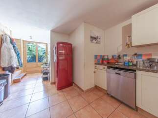 Discover this charming property featuring a well-equipped kitchen with a stylish red refrigerator.