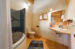 This charming bathroom features a unique design with a combination of blue and orange tiles, creating a vibrant and inviting atmosphere.
