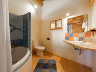 This charming bathroom features a unique design with a combination of blue and orange tiles, creating a vibrant and inviting atmosphere.