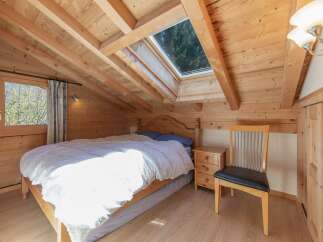 This charming bedroom features a cozy wooden interior, creating a warm and inviting atmosphere.