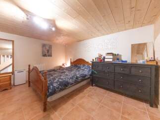 Discover the charm of this cozy bedroom featuring a wooden bed frame and a stylish dresser.