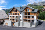 Discover this stunning mountain property featuring a modern chalet design with natural wood accents and stone facades.