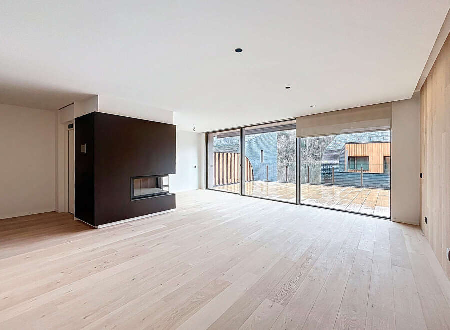 This modern living space boasts a sleek design with a dark fireplace as a focal point.