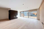 This modern living space boasts a sleek design with a dark fireplace as a focal point.