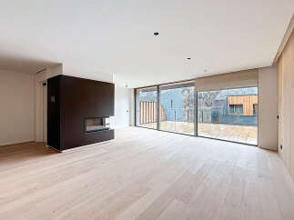 This modern living space boasts a sleek design with a dark fireplace as a focal point.