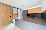 This modern kitchen boasts a sleek design with a large island and integrated cooktop, perfect for culinary enthusiasts.